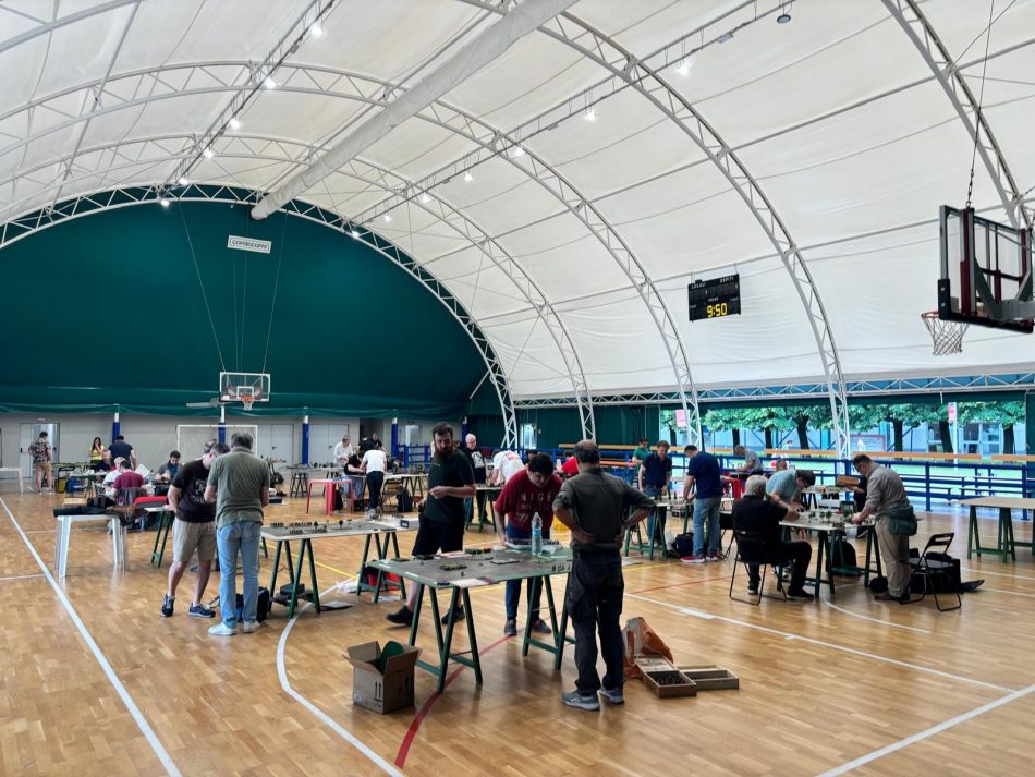 Players in Conaredo Italy, inside an athletic facility, play wargames on a basketball court.